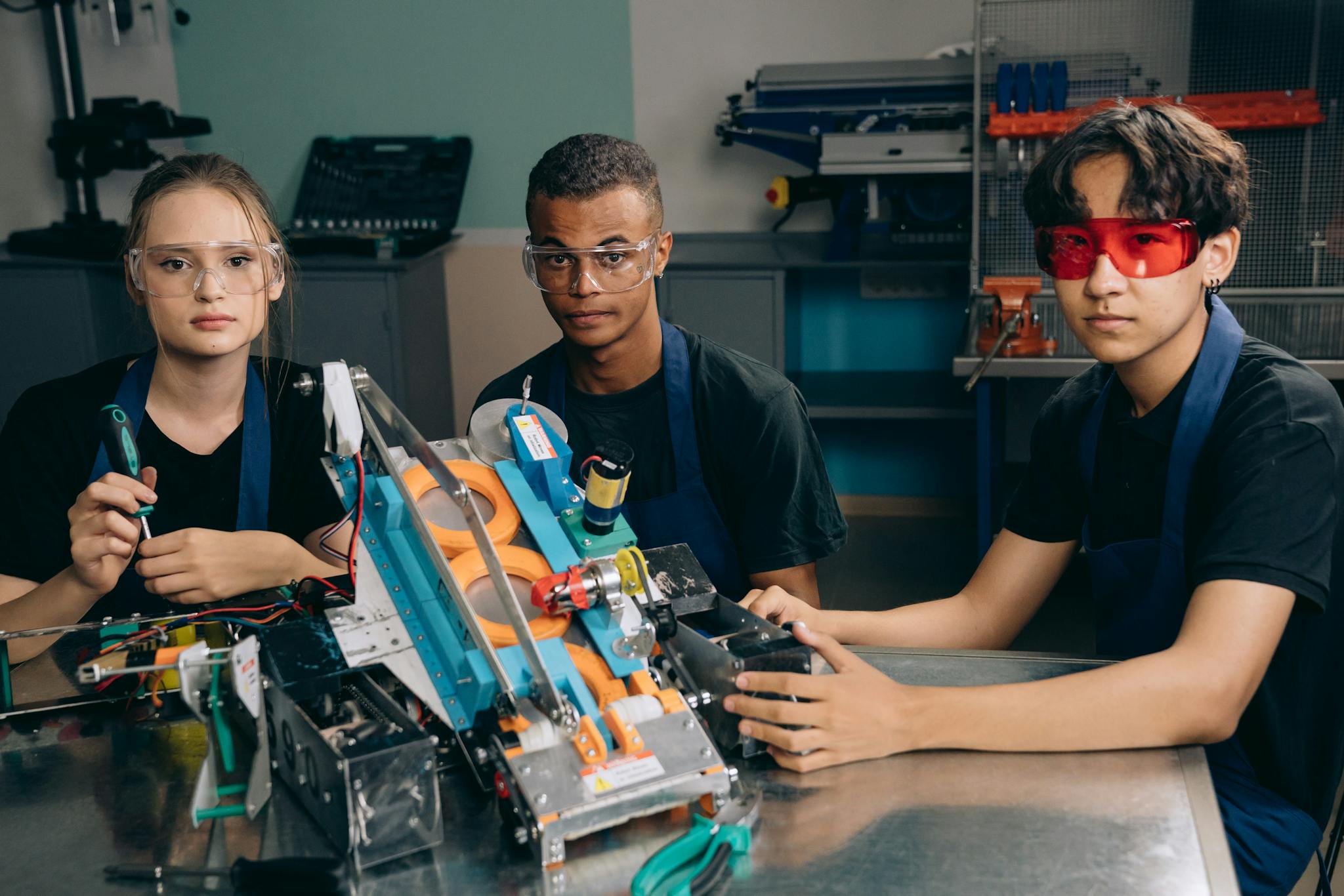 Teenagers work on a robotics project, showcasing teamwork and technical skills in a laboratory setting.
